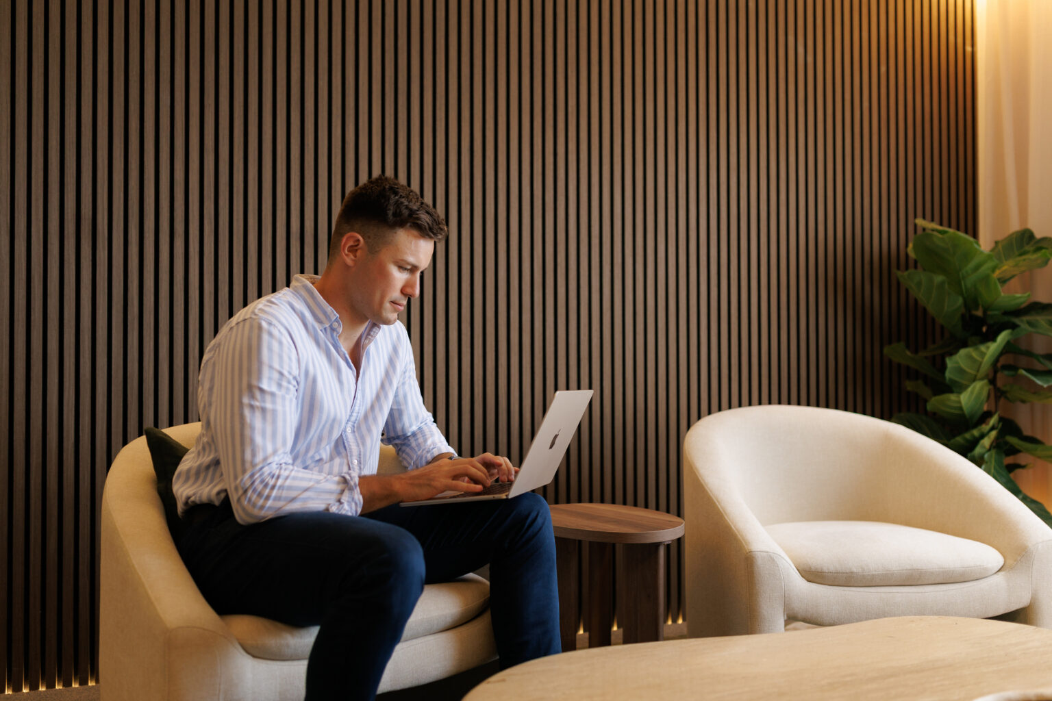 Josh Birch working on a laptop in an armchair